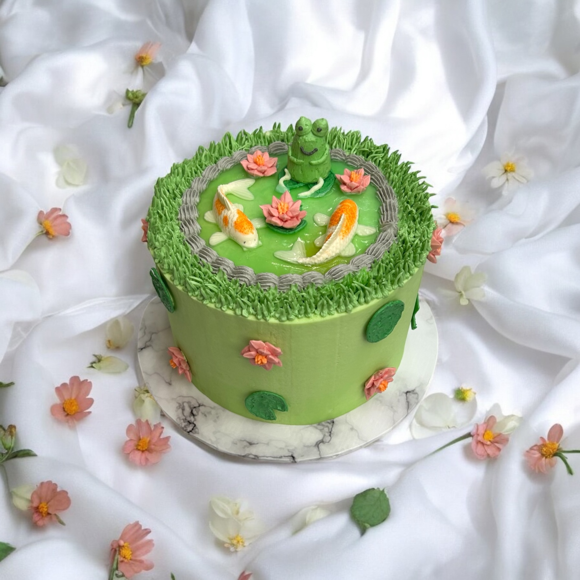Whimsical pond cake with koi fish and frog